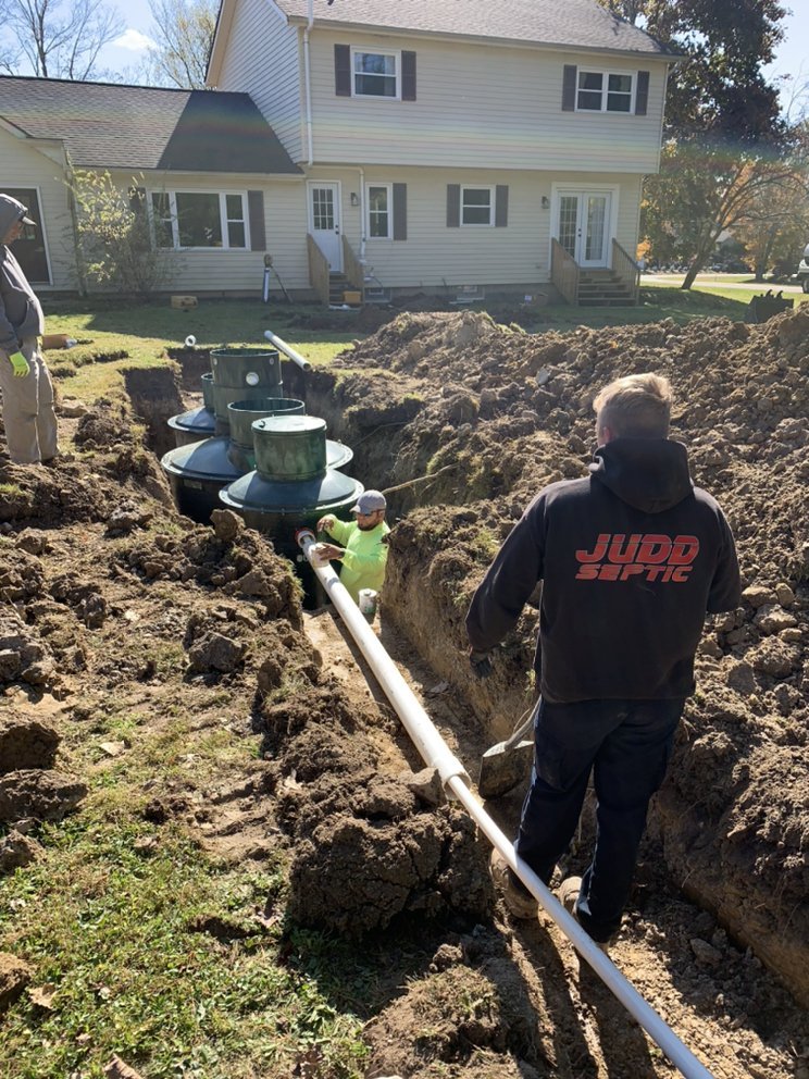 Judd Septic Tank Cleaning workers install and inspect a home septic system, showing their maintenance expertise.