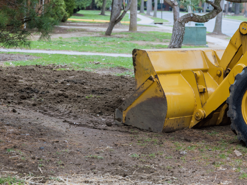 Judd Septic Tank Cleaning uses a yellow bulldozer for French drain prep in a clean, open outdoor setting.